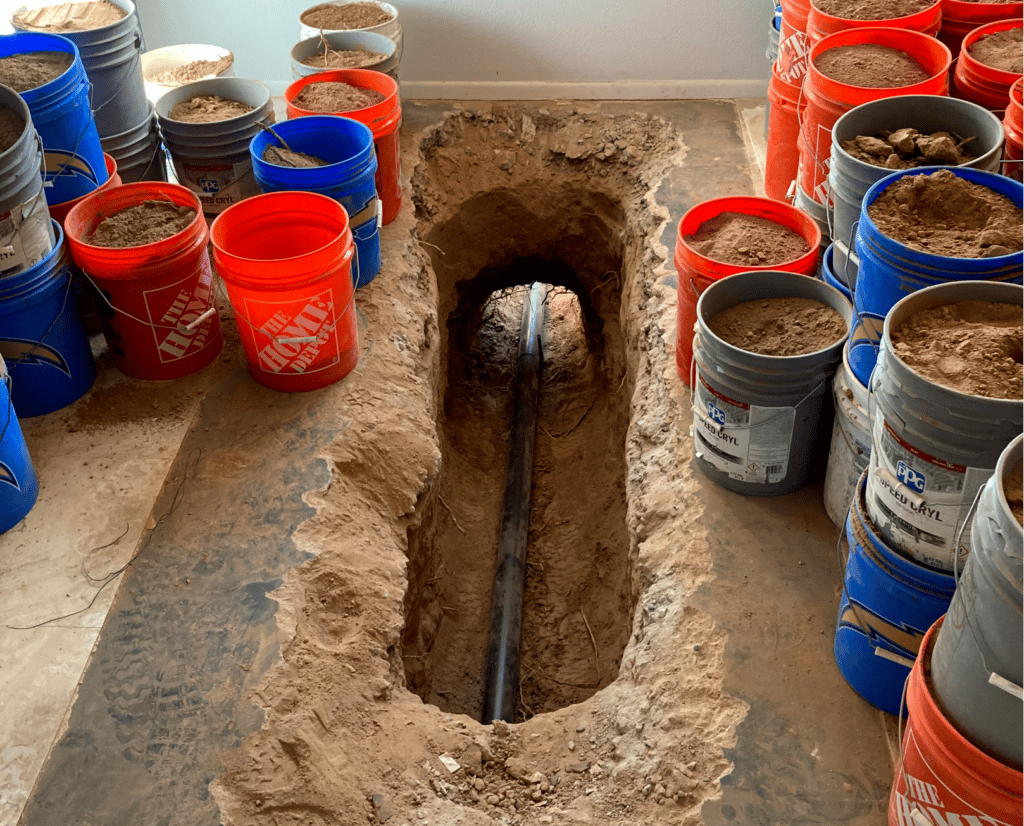 an image of many buckets near a pipe running underground that was dug out