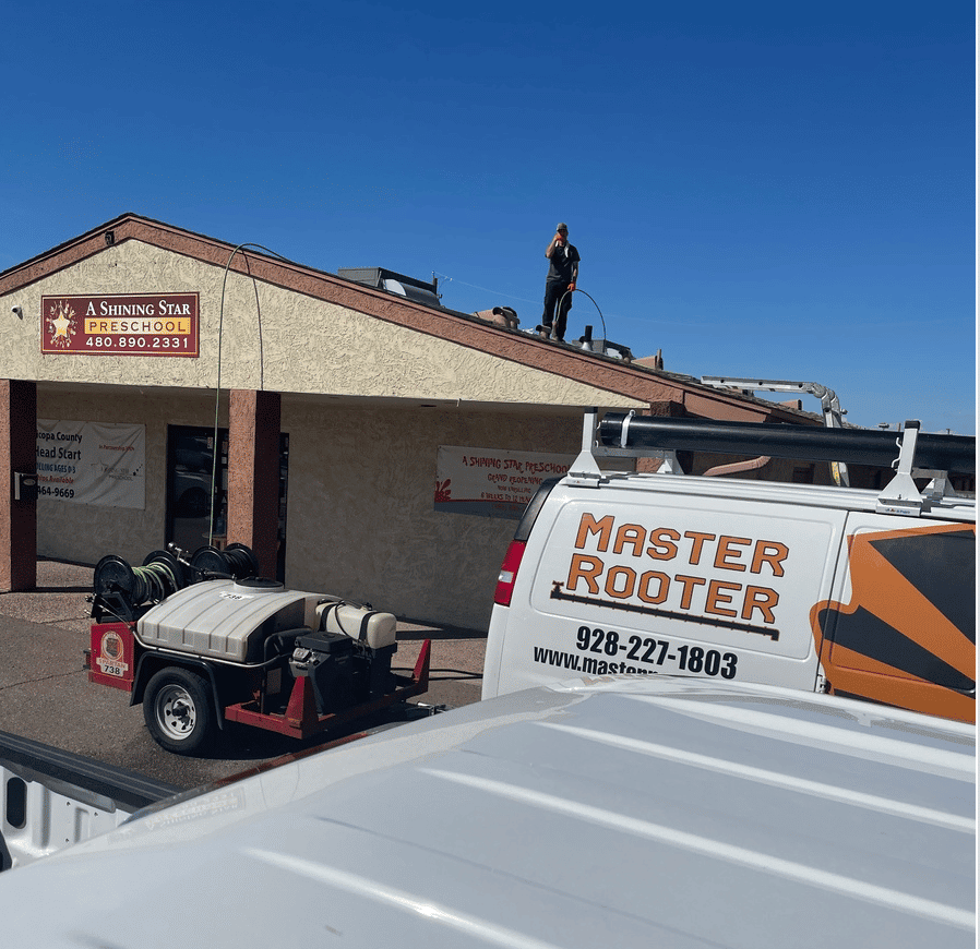 the master rooter truck in front of a yellow/brown building