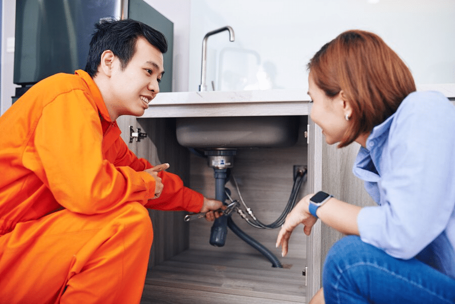 smiling-vietnamese-plumber-showing-fixed-installed-pipes-sink-kitchen-young-woman_274689-16529